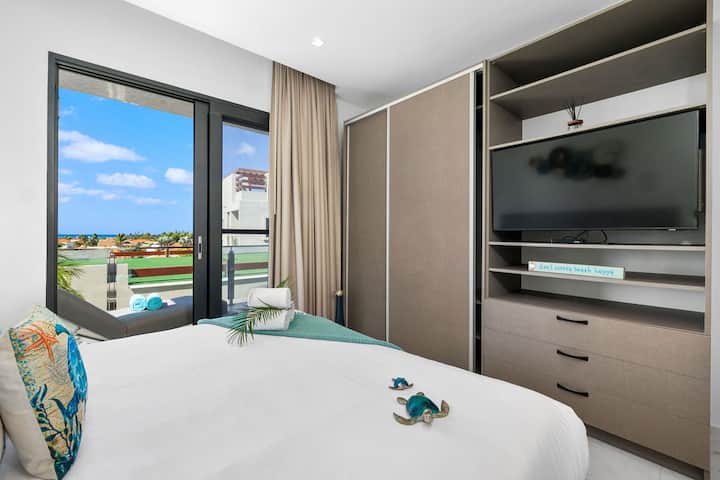 Მყუდრო საკურთხეველი დიდი ზომის საწოლითა და რამდენიმედღიანი ბრტყელეკრანიანი ტელევიზორით.

