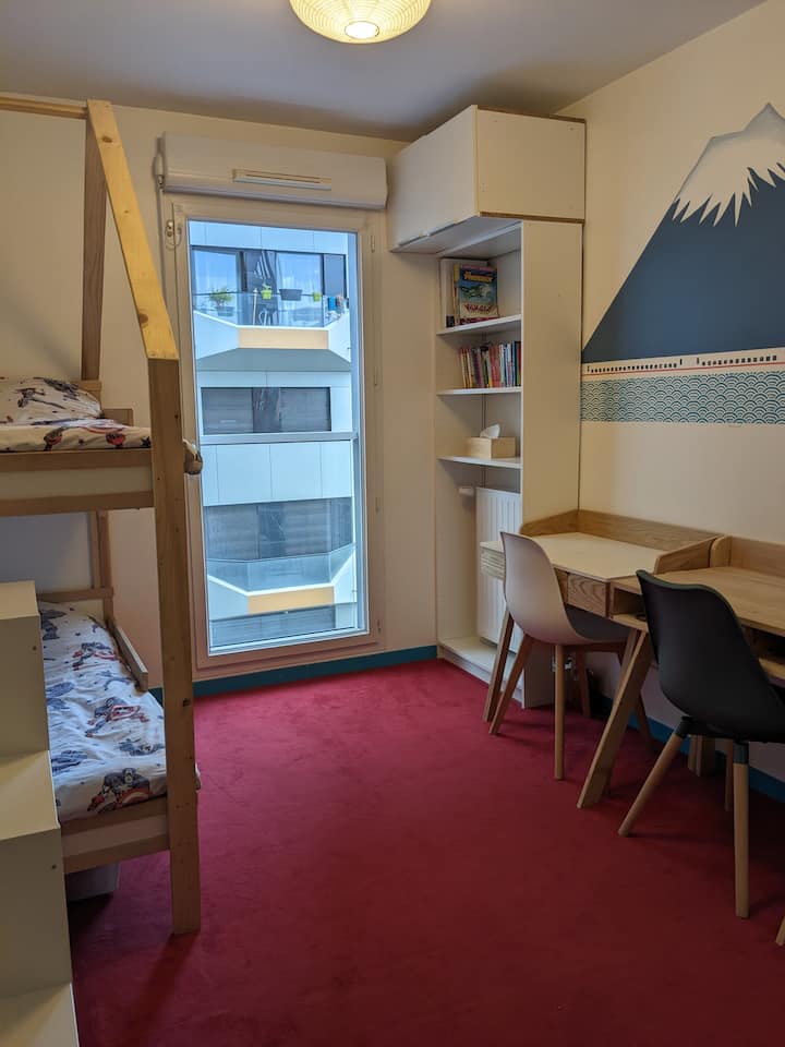 Barnsovrum med våningssäng för barn (70x160 cm), skrivbord och stolar, leksaker, böcker.