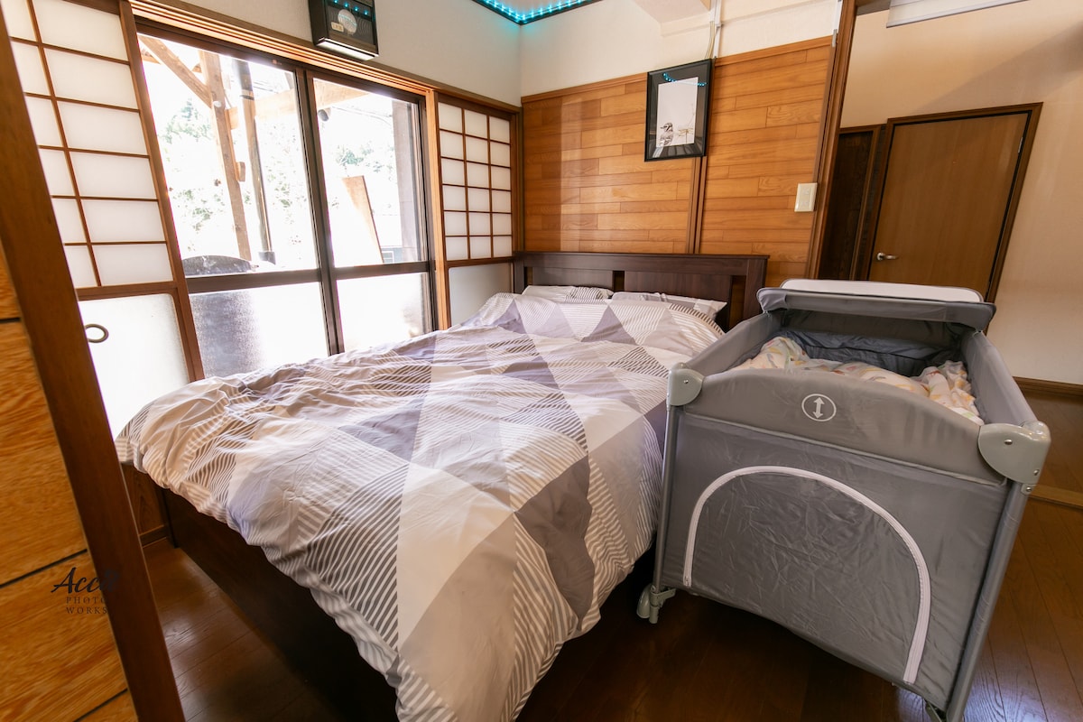 リビングスペースのダブルベッドとベビーベッド。
仕切りの衝立もあります。