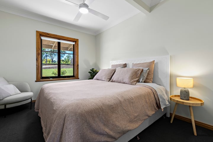 This downstairs bedroom offers vineyard views and features a king-sized Sealy Posturepedic bed with 1000 thread count linen. The bed can be converted to two king singles to provide flexible sleeping arrangements.