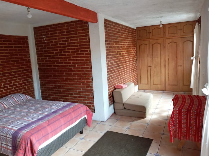 Bella camera da letto principale ben illuminata con vista sulla strada, letto matrimoniale e divano letto 