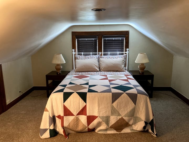 El acogedor dormitorio queen, ubicado arriba, tiene un techo bajo. ¡Cuidado con la cabeza! También hay un armario y una cómoda en esta habitación. 