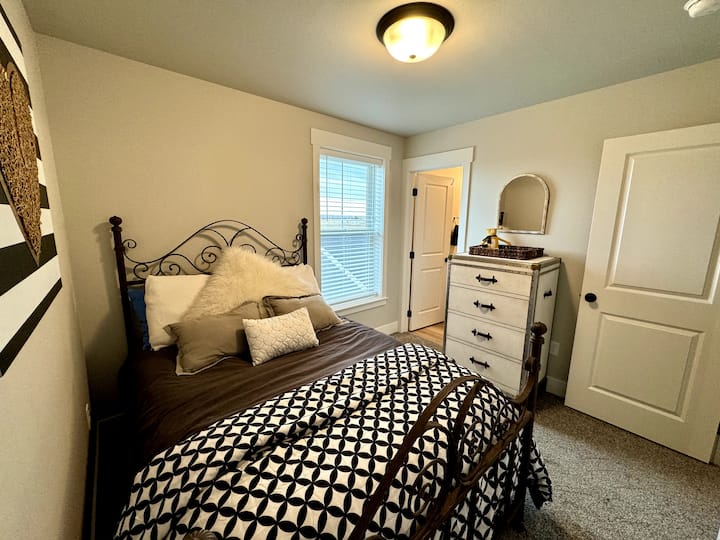 Spálňa s nočným stolíkom a komodou zahŕňa osobnú kúpeľňu so sprchovacím kútom a vaňou.