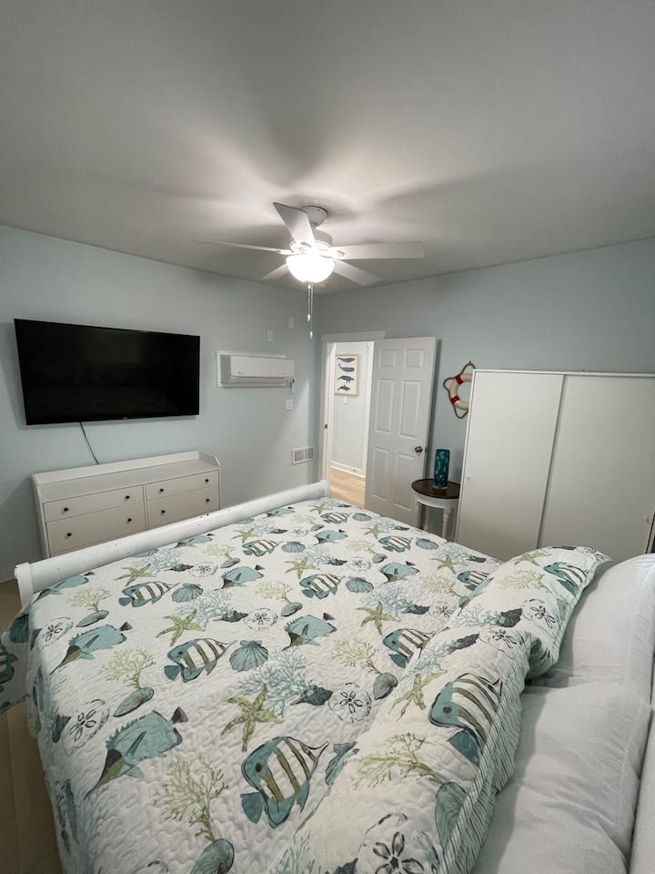 65-palcový televízor s plochou obrazovkou a manželská posteľ