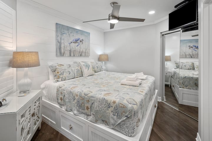 Comfortable King size bed  and TV waiting after a long day at the beach! Platform bed full of storage, night stand full of board games!