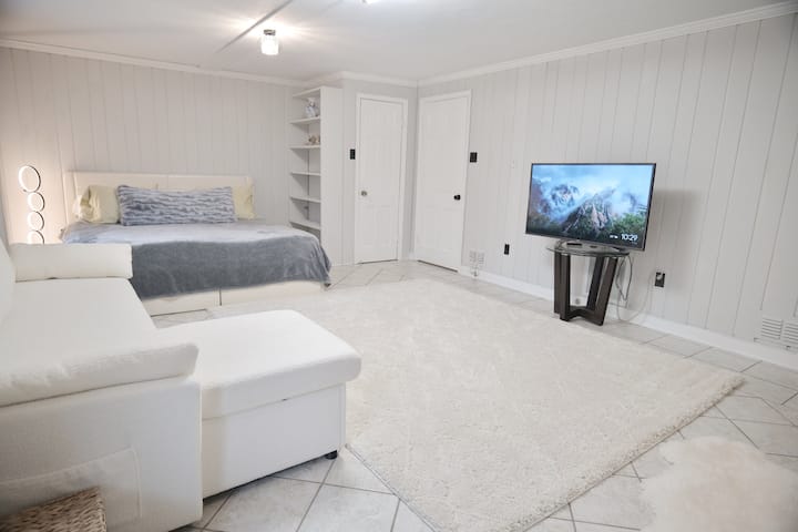 Dormitorio de invitados en la planta baja con colchón tamaño king.  Tiene TV de 55 pulgadas con Amazon Fire Stick y Chromecast y Prime Movies.  Agrega tu servicio de streaming para obtener más canales.  Esta habitación también tiene dos ventanas y una puerta para la luz y la salida. 