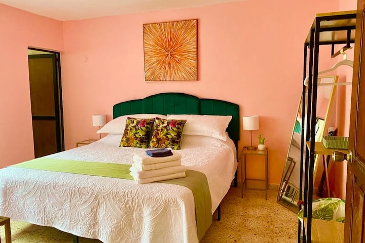 Second bedroom with firm king sized bed, ensuite bathroom, a/c unit, and 32 inch tv with streaming apps. Original terrazzo tile.