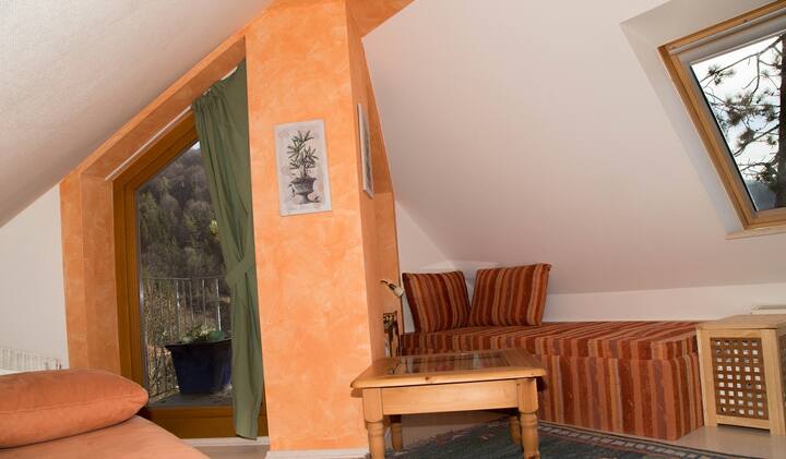 רצפת חדר עם ספה נפתחת, מיטת יחיד ומרפסת קטנה