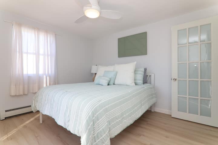 客房位于一楼，配有标准双人床、风扇和通往后露台的入口。 