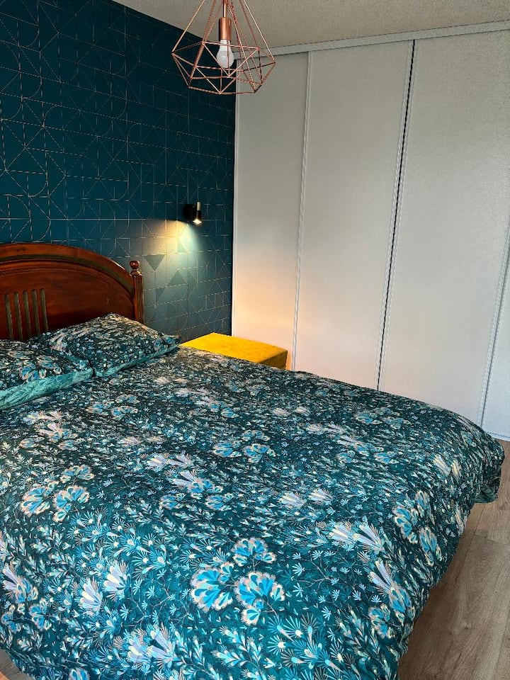 חדר שינה אחד עם מיטה זוגית, הלבשה גדולה ואזור עבודה קטן. 