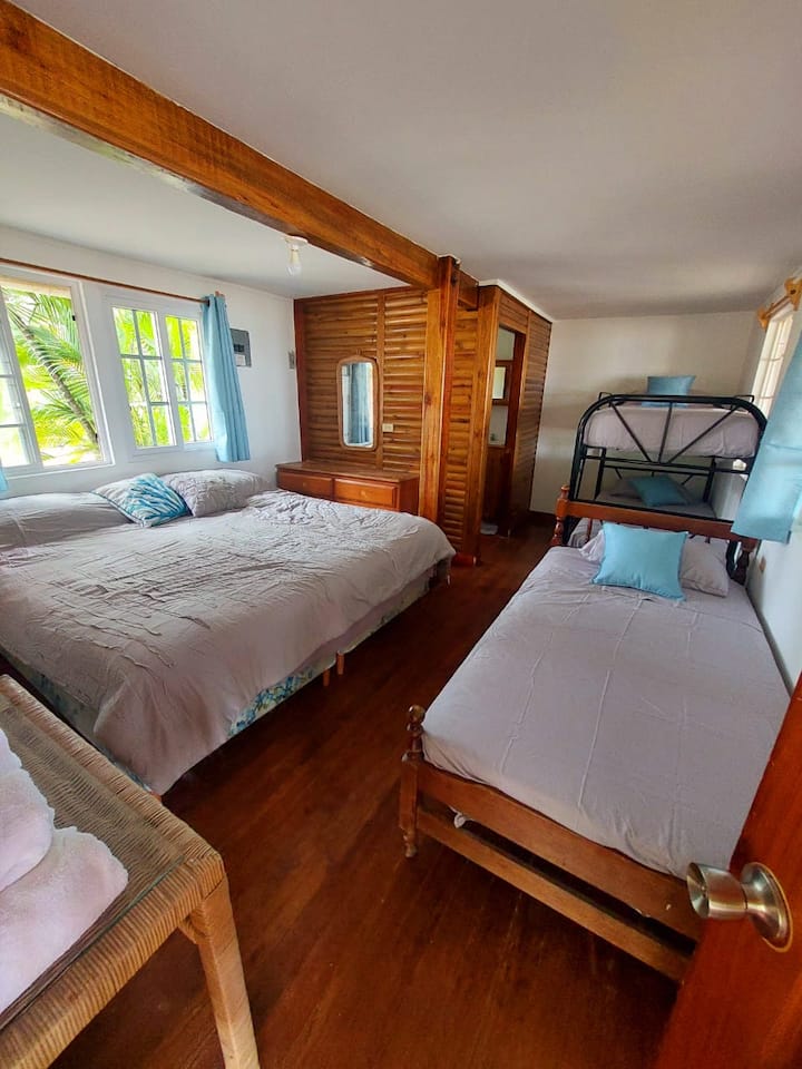 חדר בקומה הראשונה עם מיטת קינג סייז אחת, מיטת יחיד אחת, מיטת קומתיים אחת, חדר רחצה פרטי.