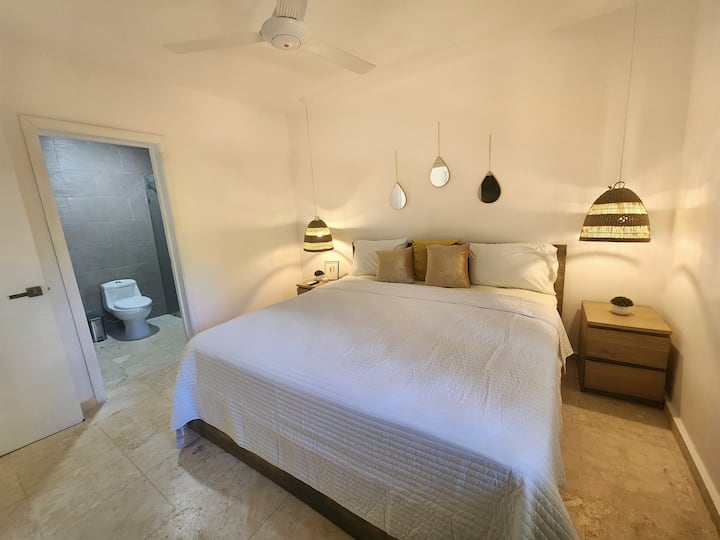 מיטת קינג סייז עם חדר רחצה ושירותים, מזגן, מאוורר תקרה וטלוויזיה. 