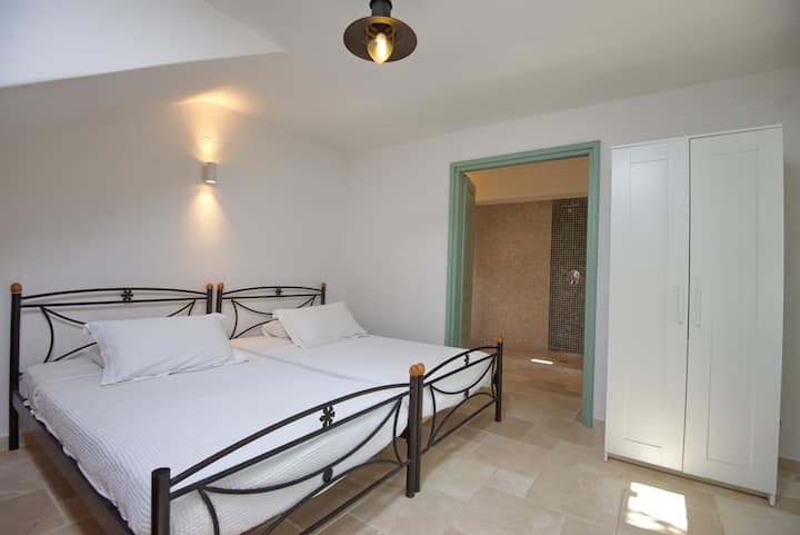 Habitación con dos camas individuales, que sale de la sala de estar a través de 2 juegos de puertas en el dormitorio . Puertas francesas a una zona de patio. Mosquitera con baño privado 
en la ventana de esta habitación , aire acondicionado . Armario y cómoda fuera de la vista 