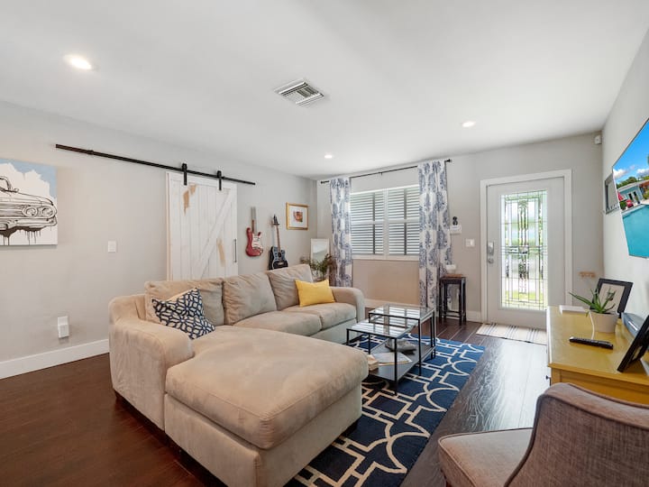 Rustic charm meets modern chill — With barn doors, poolside views, and a splash of vintage flair, this cozy living room hits all the right notes for laid-back lounging and stylish stays