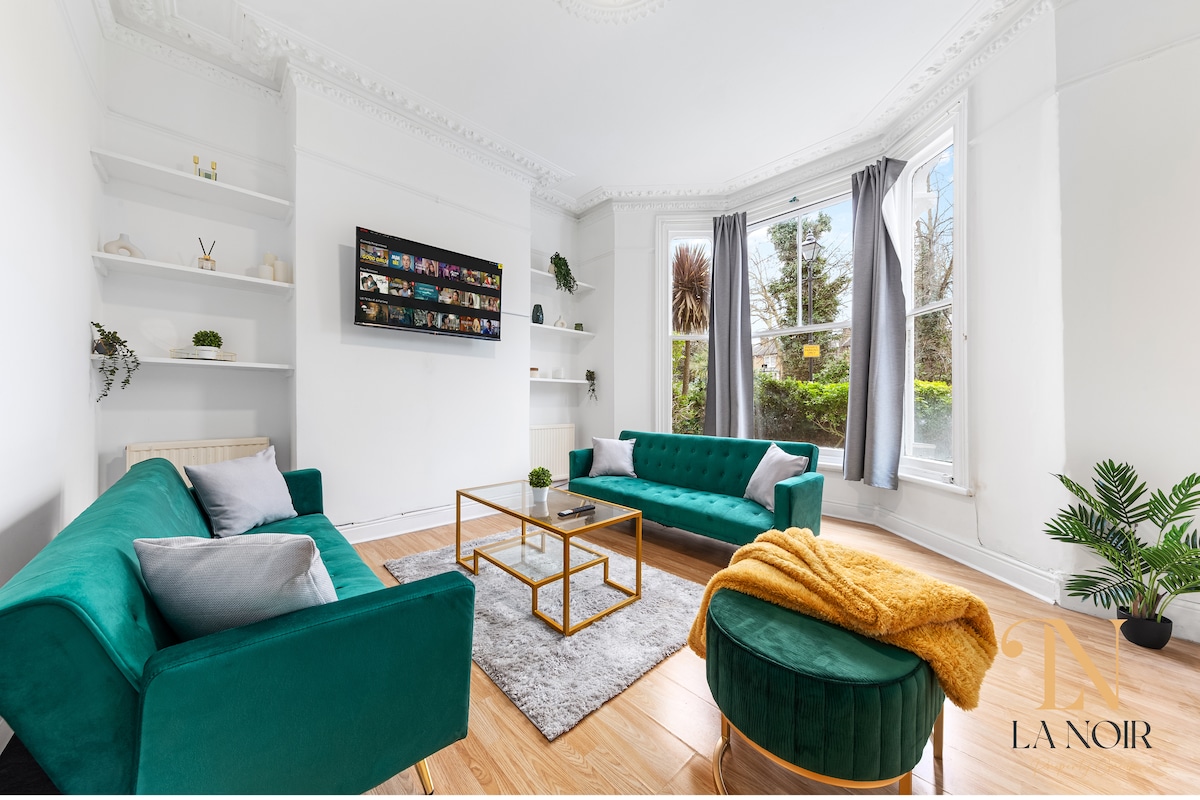 غرفة معيشة مشرقة وأنيقة مع أريكة مريحة وسرير أريكة وتلفزيون ذكي مع نيتفليكس، مثالية للاسترخاء في راحة.