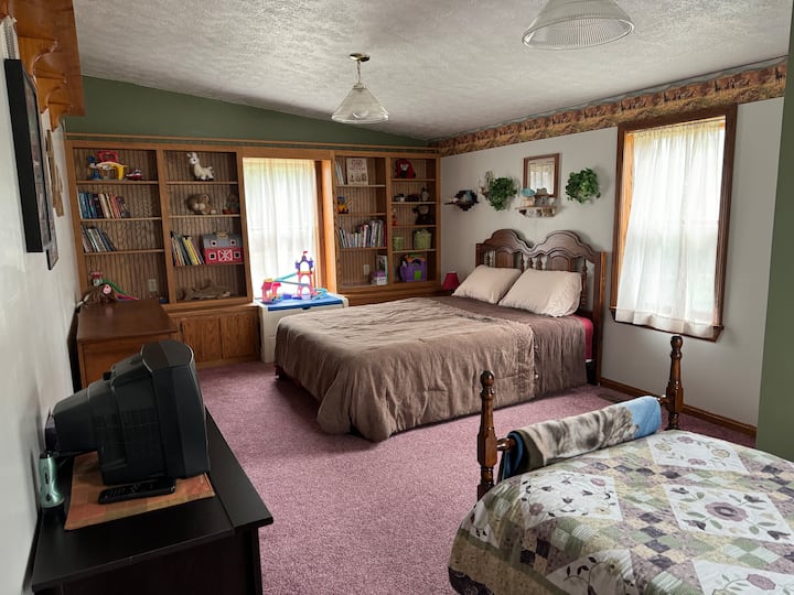 La habitación 2 se encuentra arriba. Esta habitación tiene una cama queen y una cama individual. También cuenta con libros y una variedad de juguetes para niños para usar durante tu estadía.