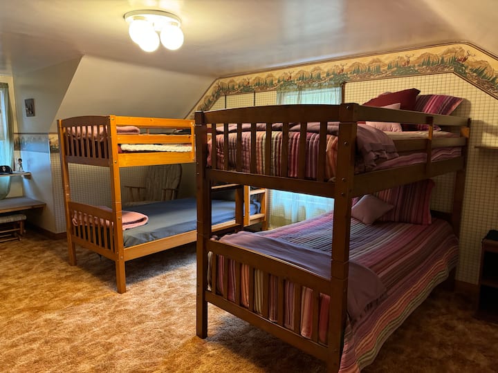 El dormitorio de invitados 4 se encuentra arriba. Este es el lugar perfecto para que los niños disfruten con 4 camas individuales que les dan un amplio espacio para dormir.