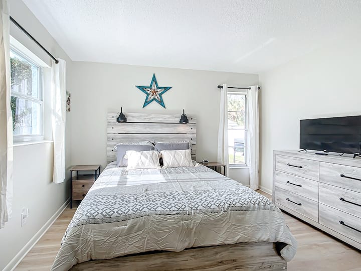 Стилската втора спална соба нуди поглед кон бујниот двор и 32-инчен телевизор Roku.
