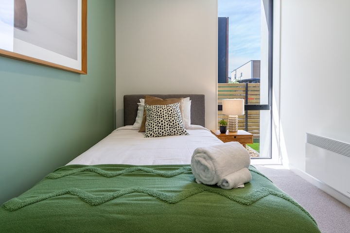 comodo letto singolo con decorazioni, cuscini, biancheria e rotolo di asciugamani di nuova qualità