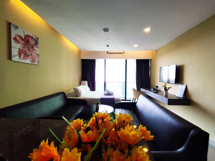 Dnevni boravak s bračnim krevetom, blagovaonskim stolom, kaučem, TV-om s TV-om i balkonom s pogledom na planine.