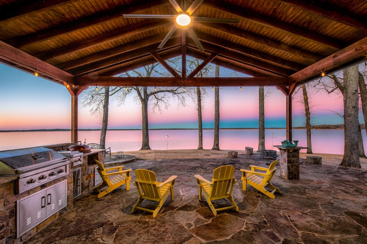 Covered lakeside patio with Adirondack chairs overlooking Lake Bob Sandlin at the Perfect Lakehouse