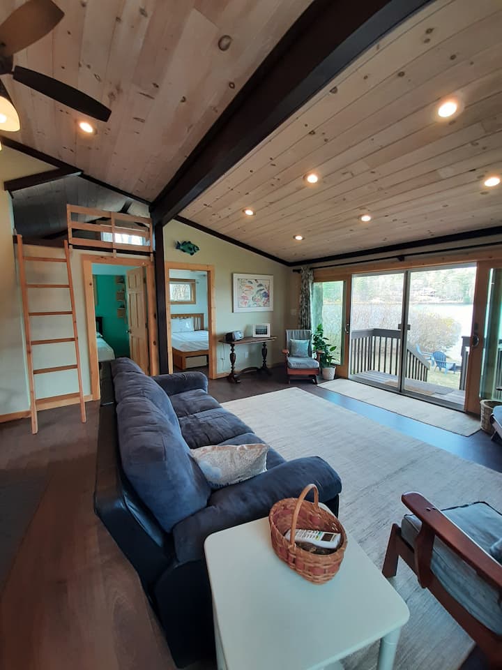 Otvorená obývacia izba katedrály s 2 vlastnými spálňami a podkrovím s manželskou posteľou.  Stena okien a posuvná lišta s výhľadom na jazero a súkromnú pláž.