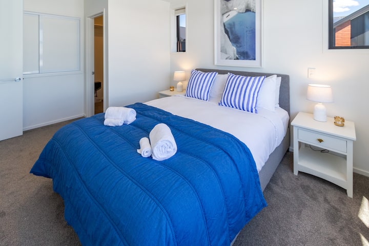 ห้องนอนกว้างขวางพร้อมเตียงควีนไซส์ผ้าปูที่นอนและผ้าขนหนูคุณภาพระดับโรงแรมโคมไฟข้างเตียงและของตกแต่ง