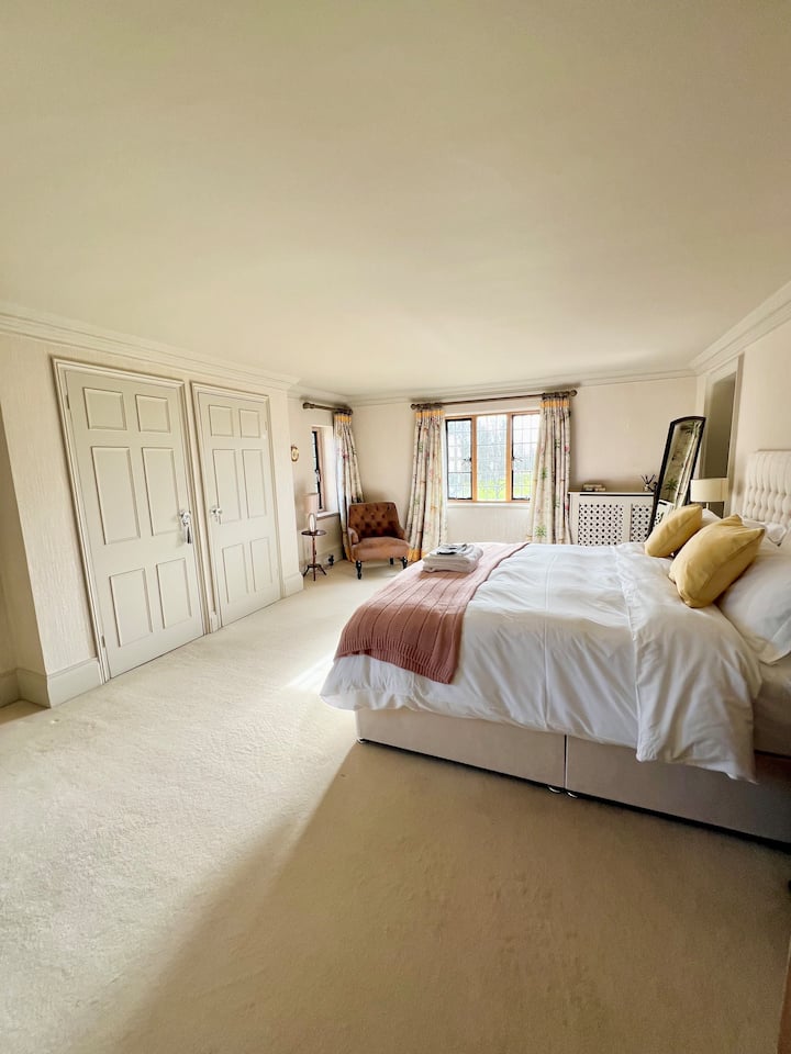 This magnificent ensuite bedroom matches generosity of space with extraordinary views of the terrace, great lawn, and gardens. Luxuriate in the blissfulness of this sun-soaked room with distinctive antique furniture and a huge ensuite bathroom. 