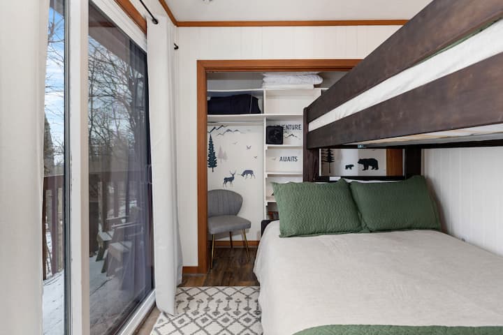 Habitación doble con literas completa con balcón privado. Cama nido adicional de tamaño individual. Televisión con todos los canales de streaming y enchufes USB.