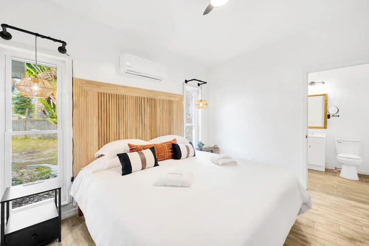Détendez-vous sur un matelas king size avec deux tables de nuit pratiques et salle de bain privée attenante pour une chambre simple et confortable.