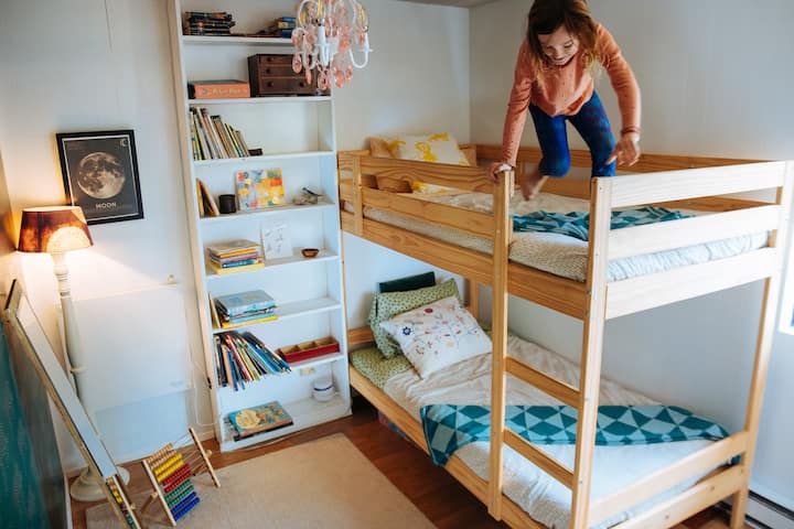 Kids room with toys and books is connected to the den with a sliding door