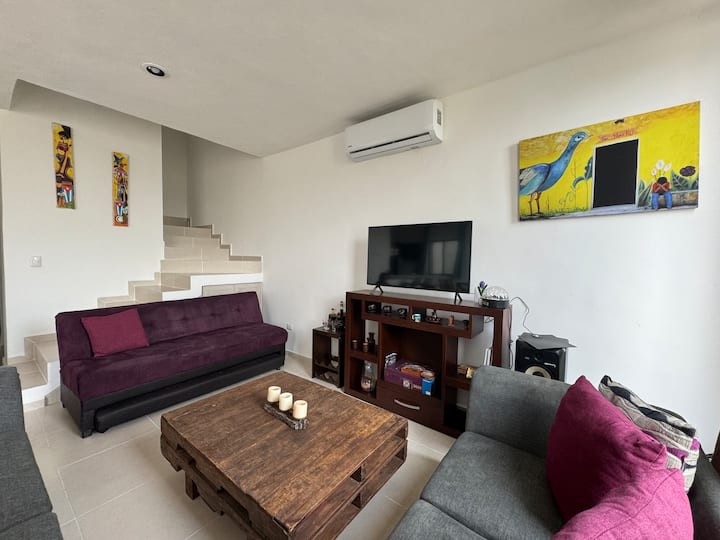 Woonkamer met een slaapbank, smart-tv met veel kanalen en airconditioning.
