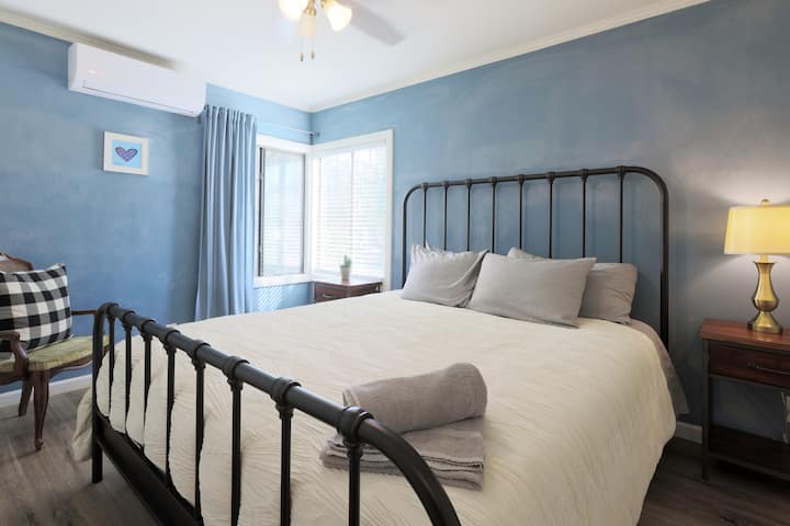 Пространа спална соба со удобен брачен кревет и клима уред за релаксирачки престој.
