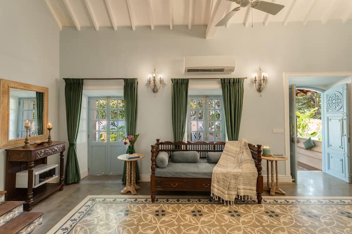 ✨This cozy corner with its vintage wooden divan, soft drapes, and pastel accents offers a charming retreat with views of the lush garden just beyond✨