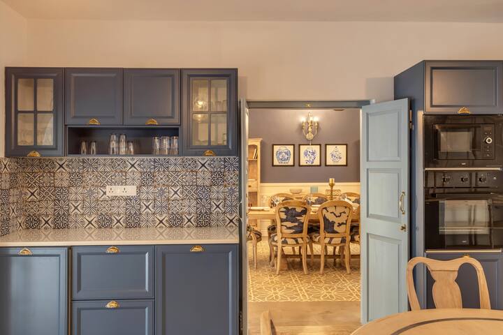 ✨This navy blue kitchen opens into an elegant dining room, with detailed tilework and warm lighting tying both spaces together beautifully✨