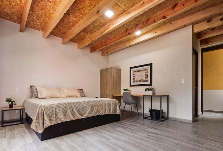 غرفة نوم 1 سرير بحجم كبير مع حمامها الخاص وتلفزيون. كما تحتوي على أريكة بحجم كبير.