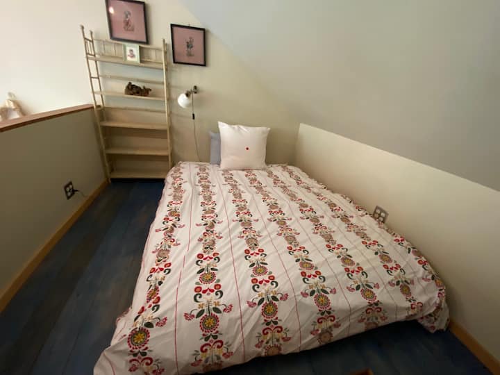 Loft en el dormitorio con una cama tamaño queen