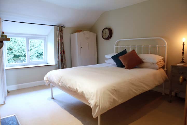 La chambre des maitres avec lit king.  Les voyageurs aiment souvent s'asseoir par la fenêtre et lire un livre ou regarder le monde passer.  La fenêtre fait face à l'église et vous n'êtes donc pas visités.