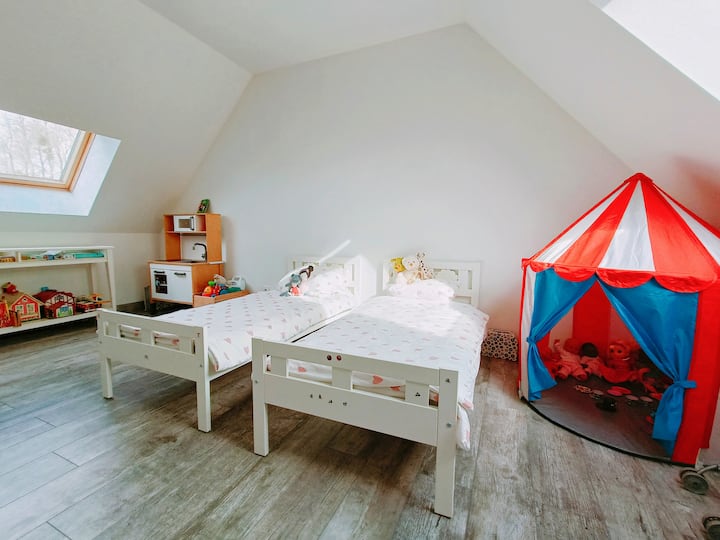 Втората спалня на горния етаж с две много малки детски легла, както и много игри и играчки