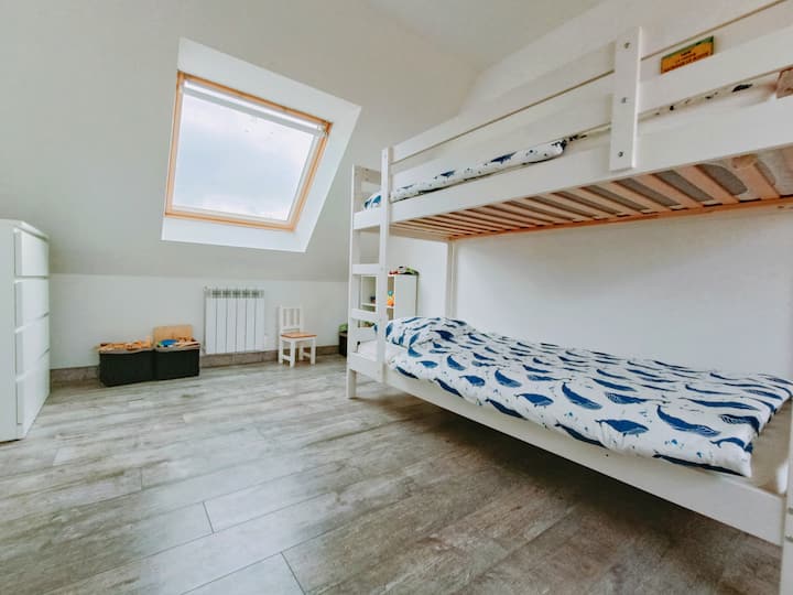 На горния етаж има първа спалня с двуетажно легло и красива зона за игра. 