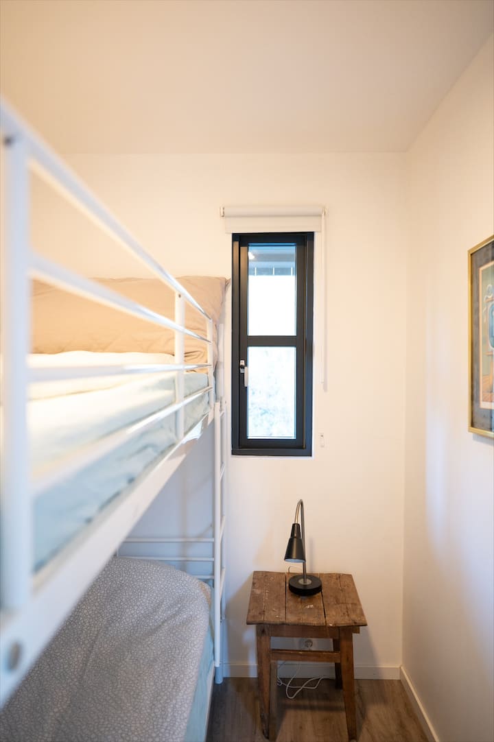 غرفة نوم في الطابق السفلي بسرير بطابقين. 