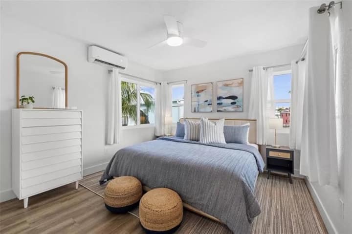 Spavaća soba s velikim bračnim krevetom, stropnim ventilatorom, mini split klima-uređajem, prozorima koji se otvaraju za svjež zrak, ormarom i perilom/sušilicom 