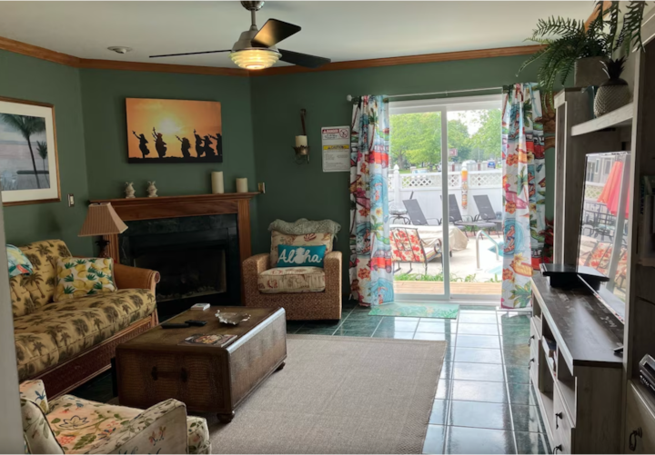 Séjour au 1er étage avec grande télévision, portes coulissantes donnant sur la véranda et la piscine.