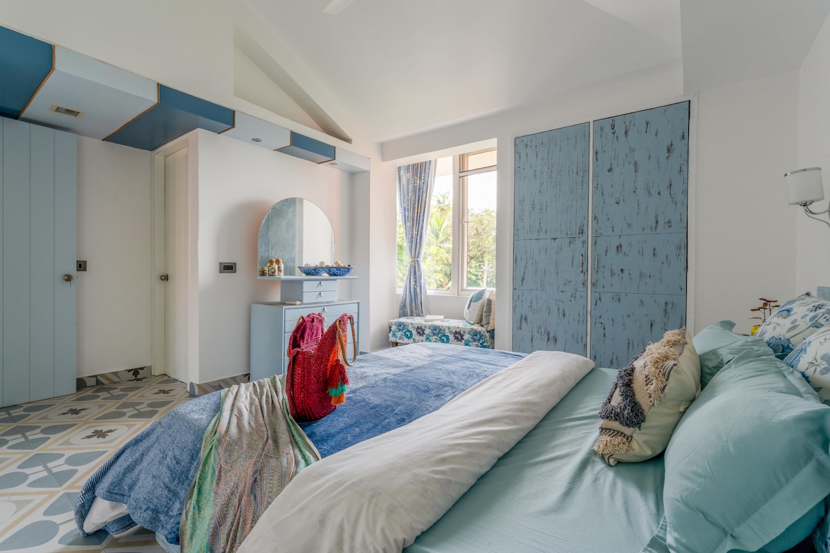 Dormitorio con cama tamaño queen, tocador, armario, asientos y baño privado 