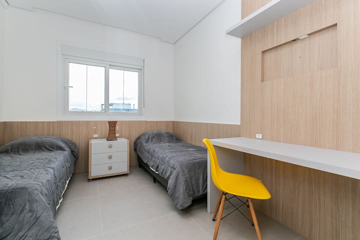 Chumba cha kulala kilicho na vitanda viwili na sehemu ya kufanyia kazi