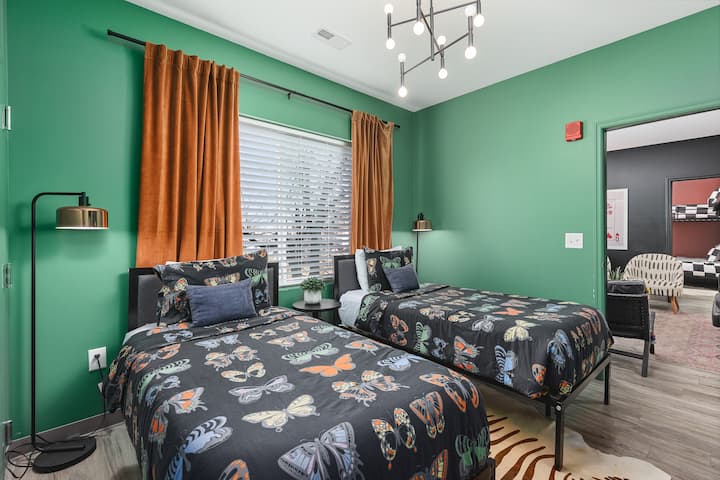 4号卧室配备两张单人床、一台智能电视、遮光窗帘和挂衣空间。