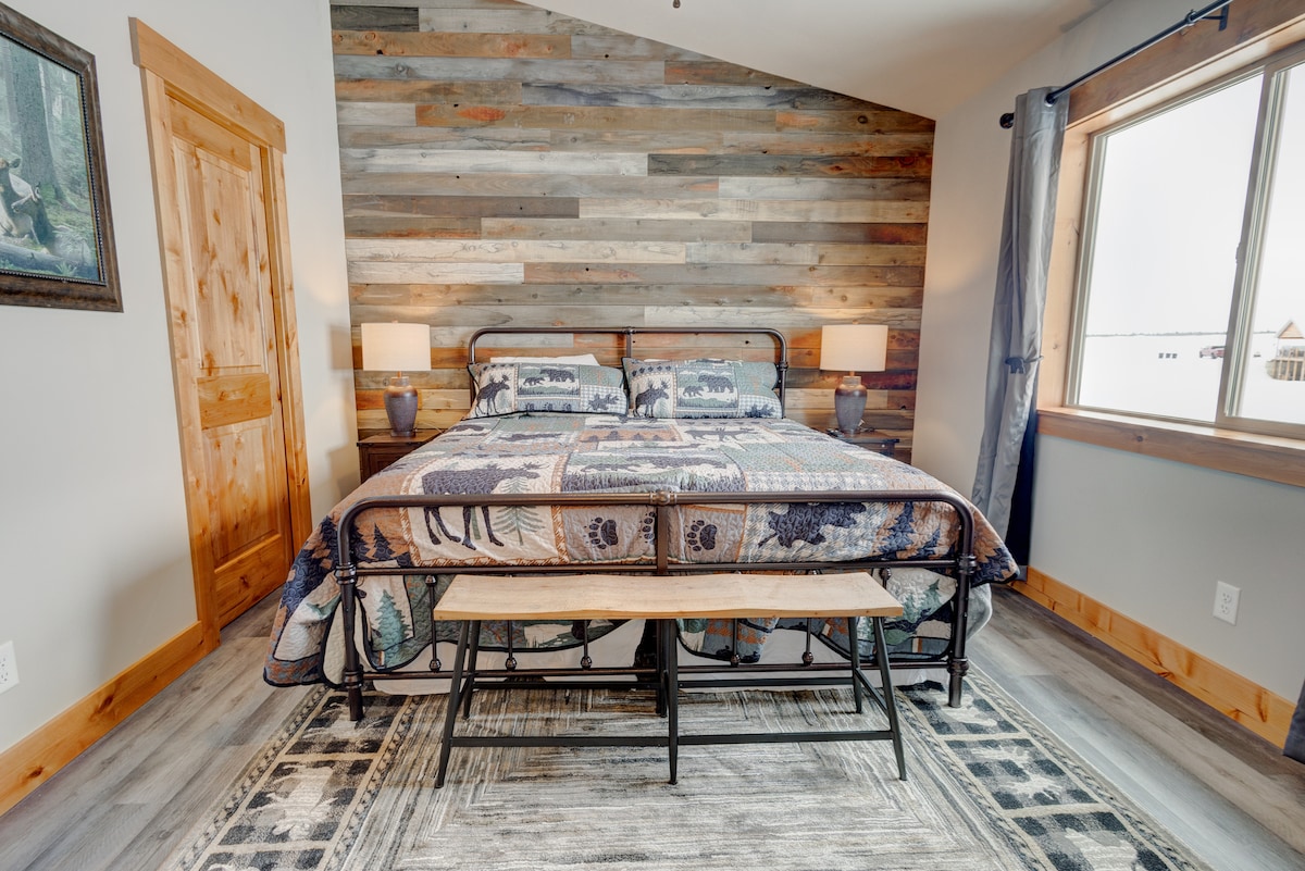 სუფთა და მარტივი საძინებელი, რომელშიც არის საწოლი და ფანჯარა, რომლიდანაც ბუნებრივი სინათლე შემოდის. 