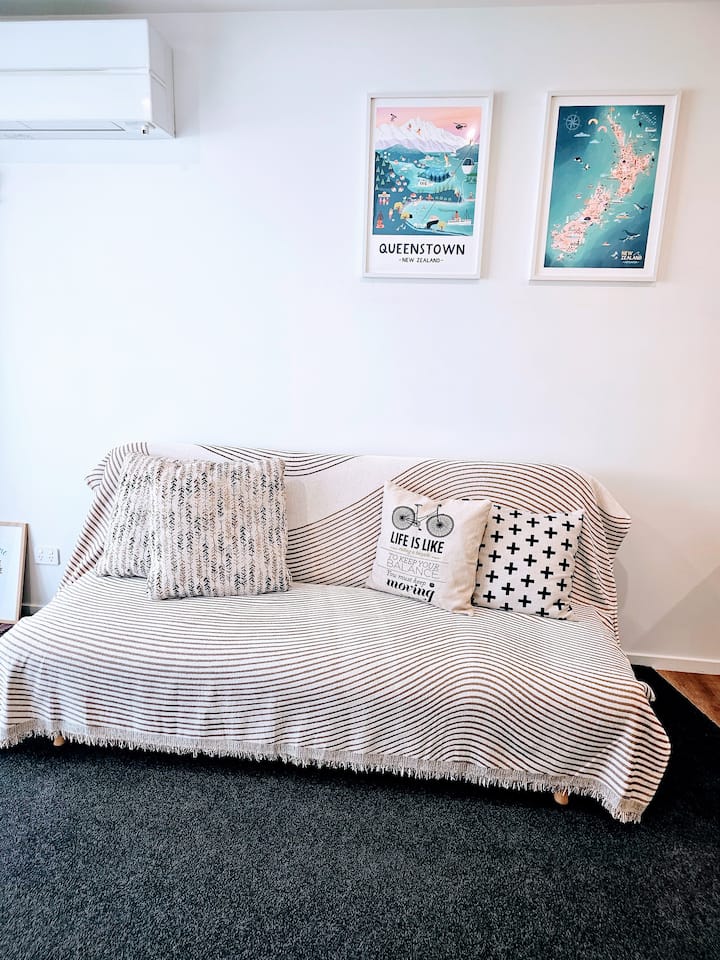 חלל מגורים מזמין שלווה ומנוחה, מעוטר ביצירות אמנות מרתקות על הקיר.