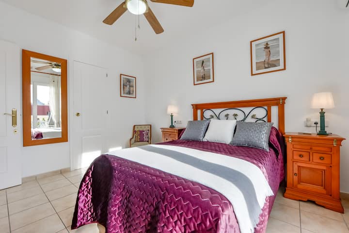 Dormitorio 2 en la planta superior con armarios y puertas que conducen al balcón.