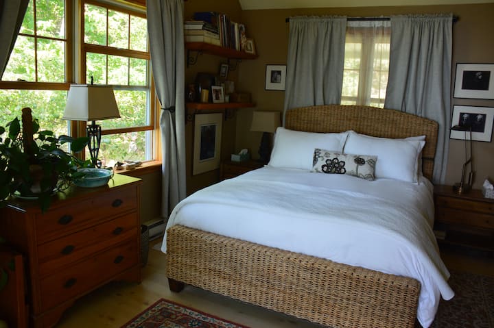 One of two main floor bedrooms with queen bed has sliding glass doors leading out to the waterfront.